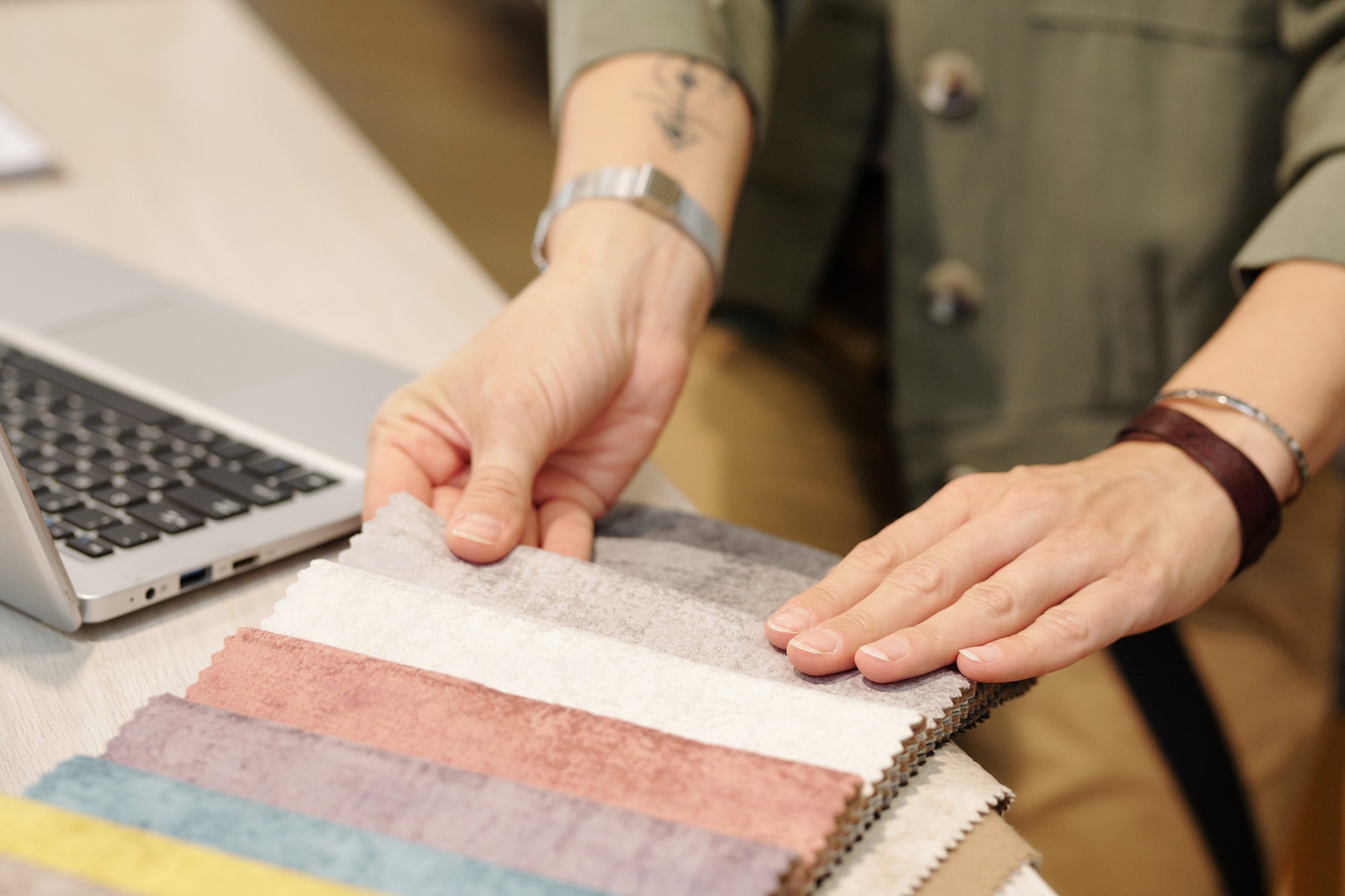Hands of manager of studio of interior design looking through fabric samples