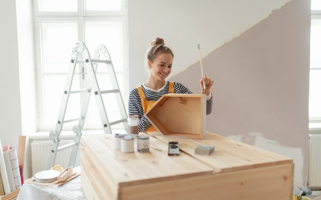 Happy young woman remaking shelf in her new flat. Concept of reusing materials and sustainable