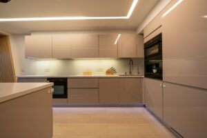 Light home interior in beige colors with open kitchen and dining area with bar counter.