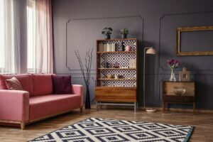 Retro wooden cupboard with books and decorations standing in dar