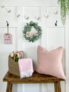 Stylish home entry with board and batten wall and pink decorations for spring or Valentine’s Day