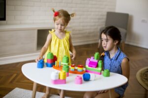 Two little girls play with blocks in the room