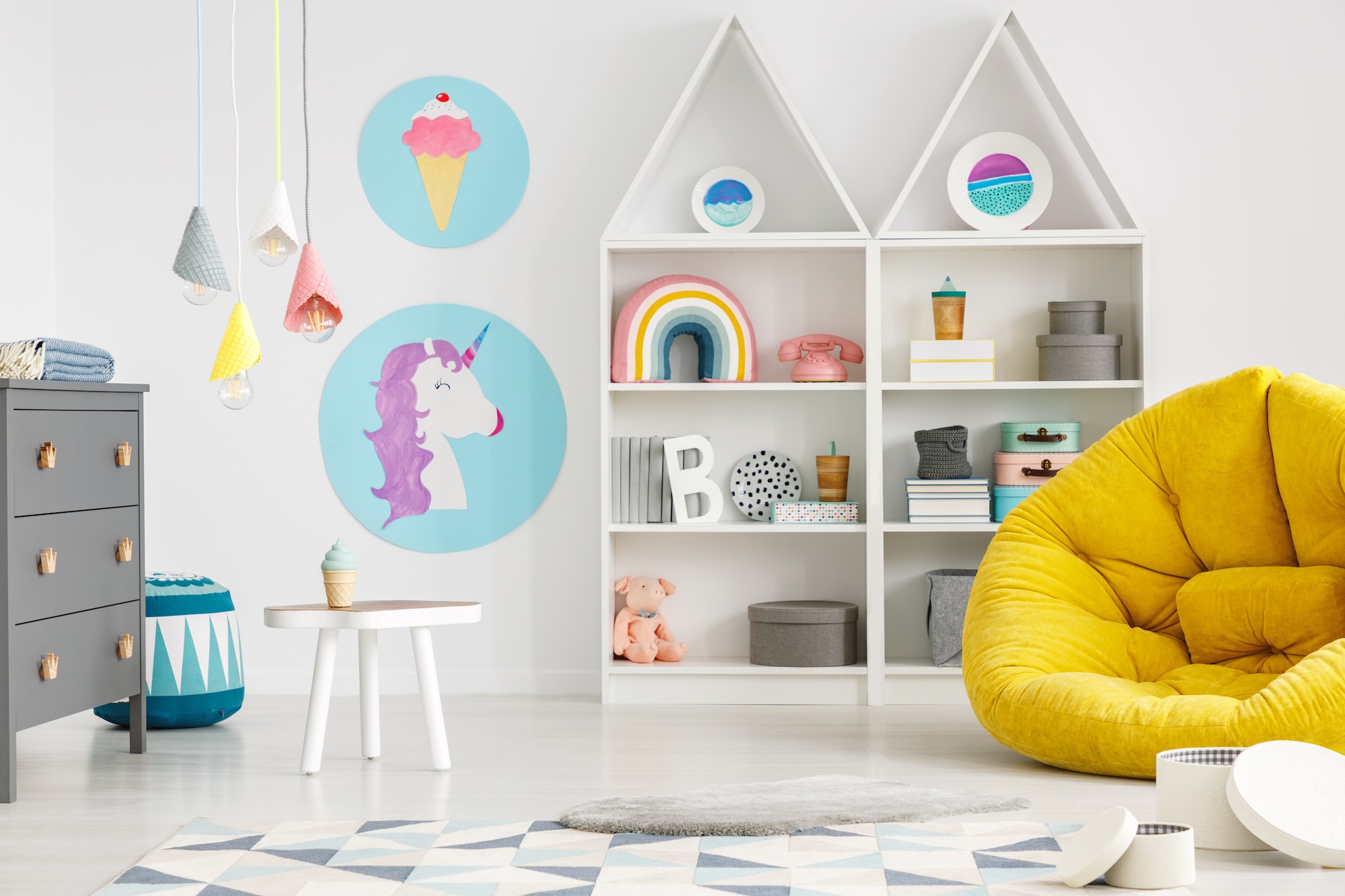 Yellow pouf in colorful child's room interior with lamps and pos