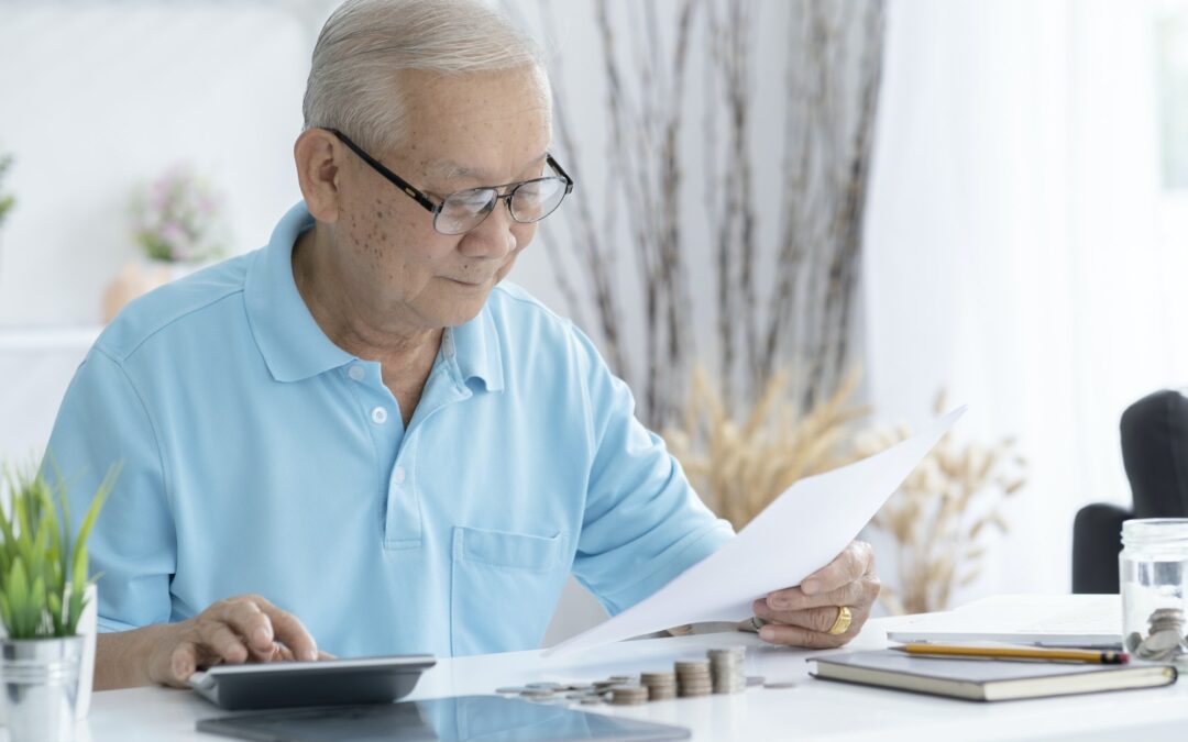 Senior man calculating taxes at home.